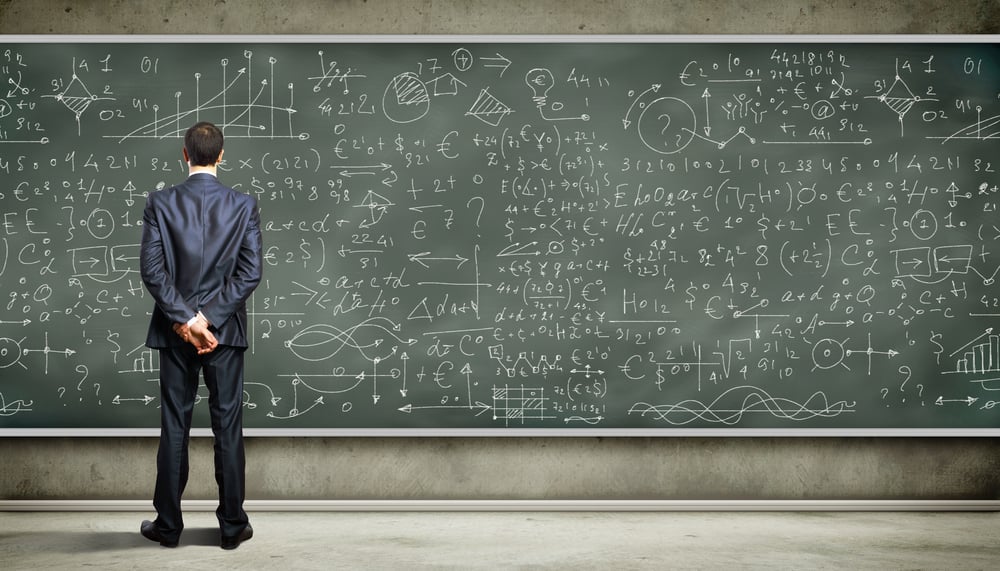 Business person standing against the blackboard with a lot of data written on it